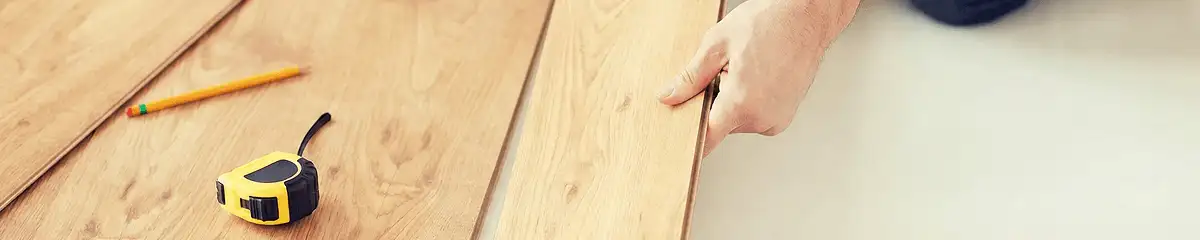 A professional installing wood flooring in Anchorage, AK